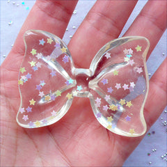 Transparent Bow Cabochon with Star Confetti | Large Bow Cabochon with Glitter Sprinkles | Kawaii Decoden Crafts | Resin Flatback | Fairy Kei Phone Case Decoration | Chunky Jewellery Making (1 piece / Clear / 54mm x 41mm / Flat Back)